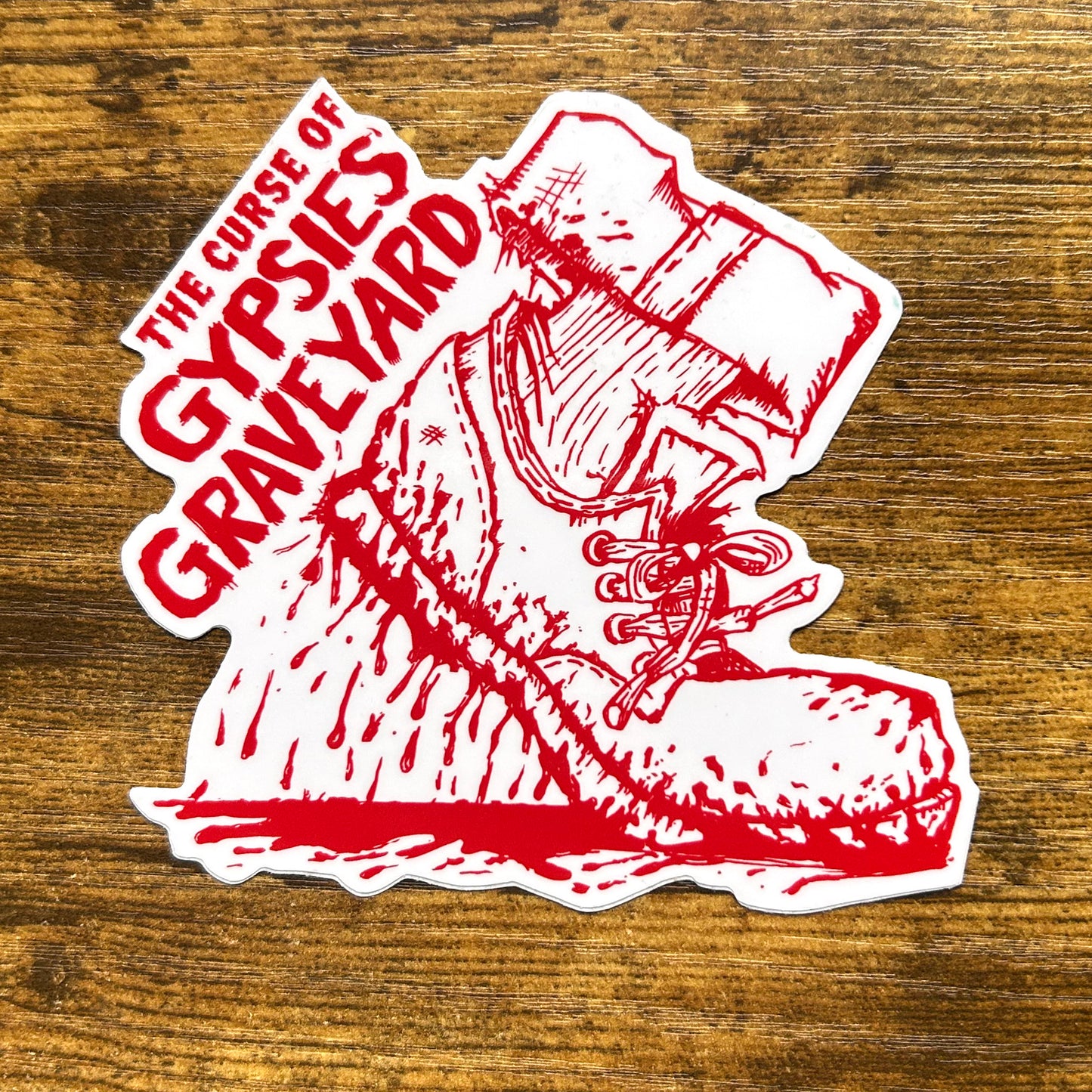 Gypsies Graveyard Indiana Sticker ie, white shoe red blood dripping. Die cut sticker on wood table says "the curse of gypsies graveyaed"