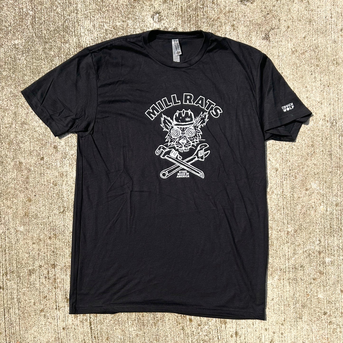 Black t-shirt with white graphic design of rat in helmet says mill rats steel made in americaon a textured beige surface