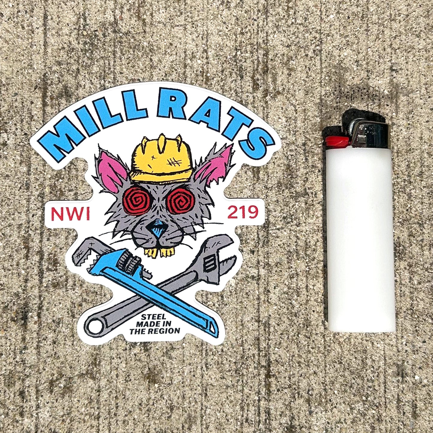 Sticker with 'Mill Rats' design and a lighter on a textured surface