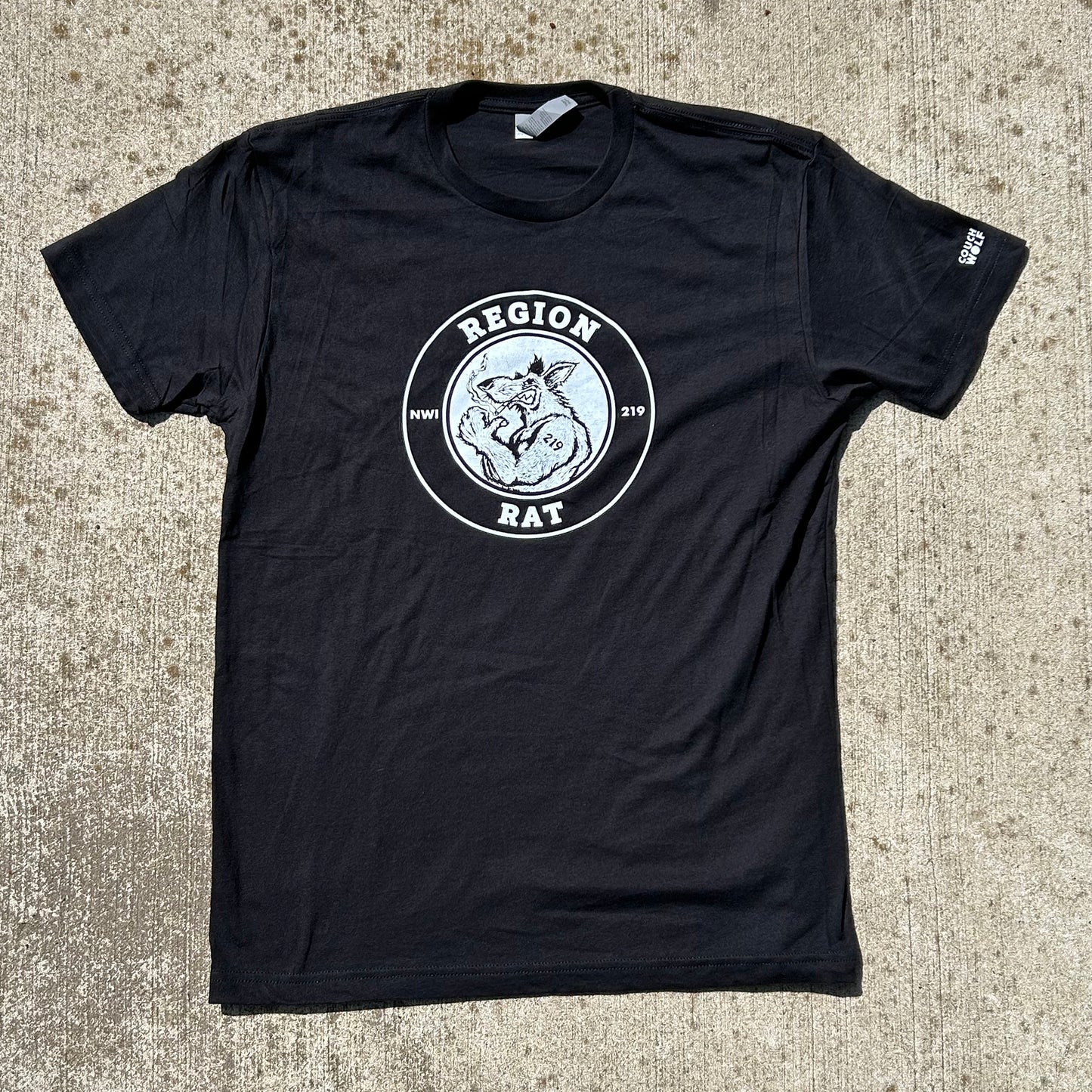 Region Rat t shirt black short sleeve shirt says region rat nwi 219 in a ring with flexing region rat with cigarette art in the center shirt shown on tan concrete background