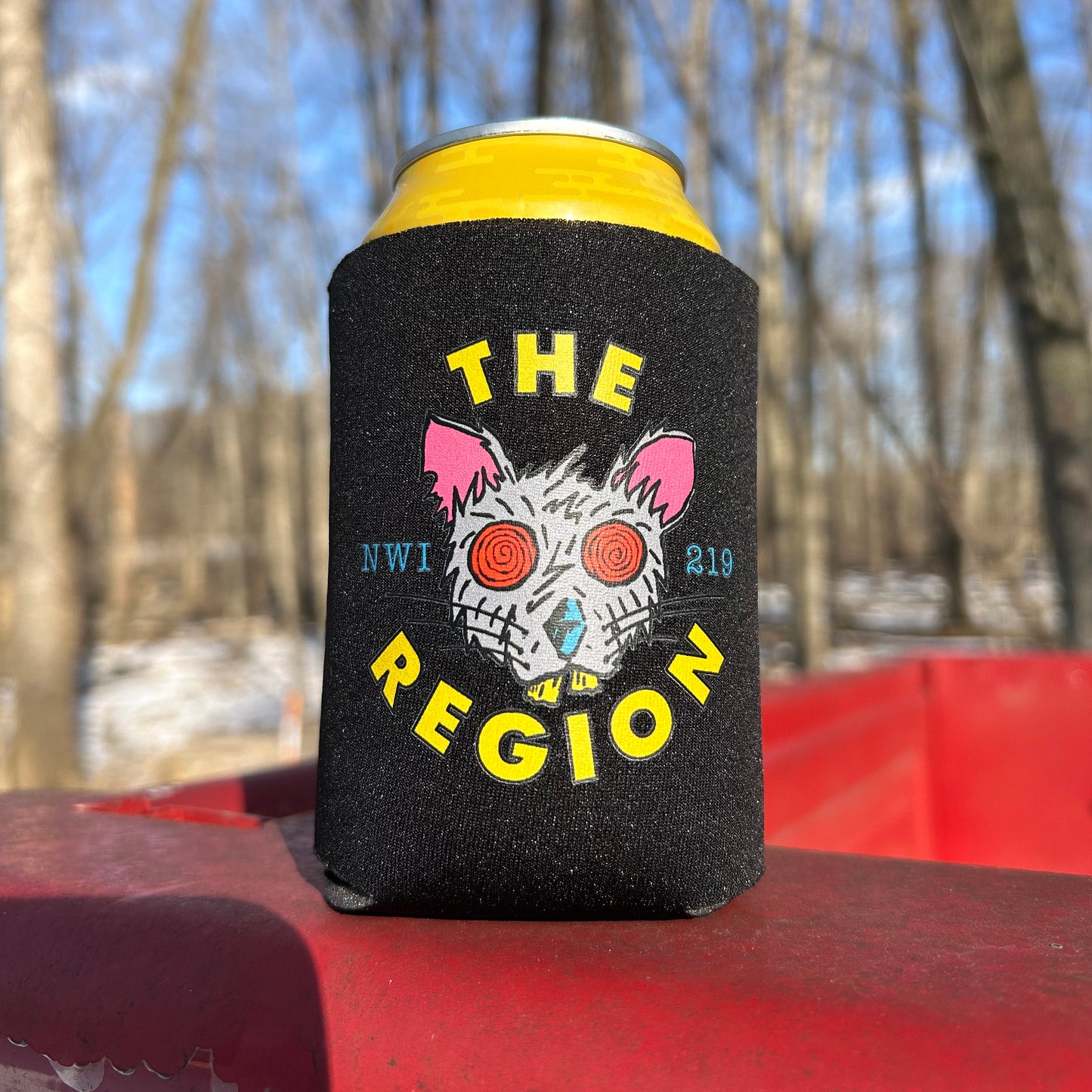 Region Rat Northwest Indiana can cooler foam can cooler artwork of rat with red eyes says "The Region NWI 219" on red surface winter woods in background, yellow can