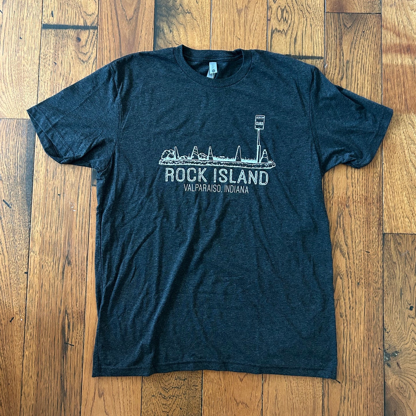 Rock Island Valparaiso Indiana t-shirt short heather black shirt with white ink featuring Rock Island artwork of rocks and parking cones on brown wood floor background designed by couch wolf