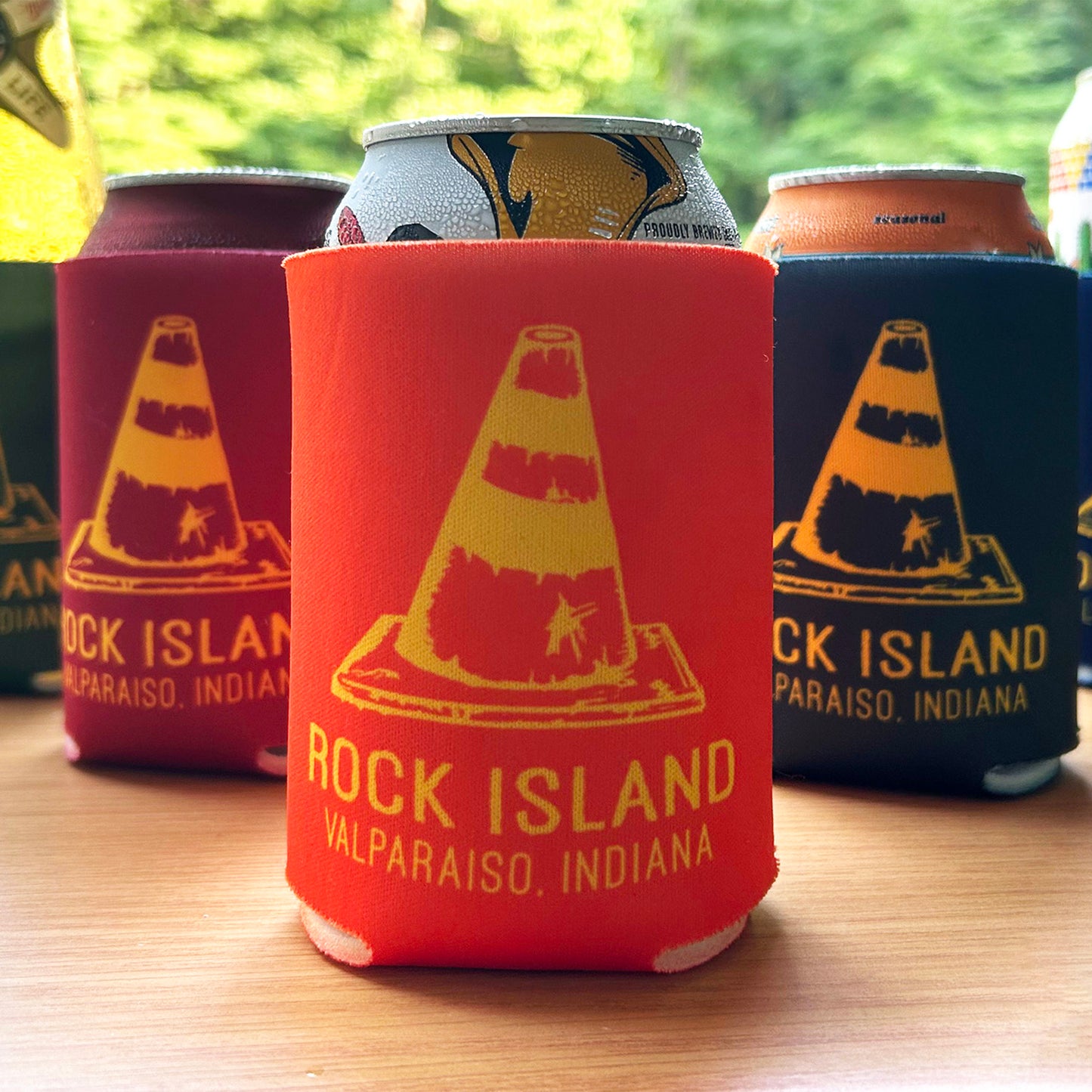 Rock Island Valparaiso Can Cooler several cans in can coolers with road cone artwork that says "Rock Island Valparaiso, Indiana" Orang can cooler with yellow ink in front