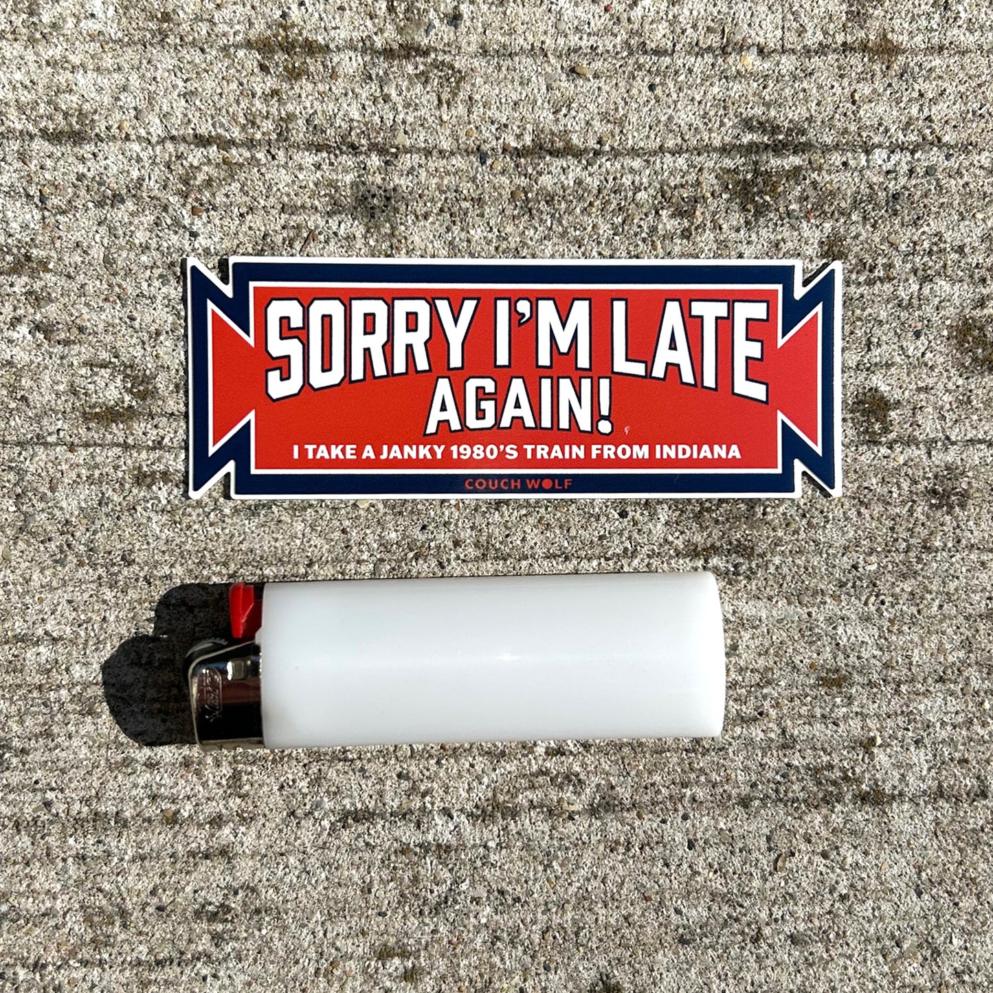 South Shore Sticker with 'Sorry I'm Late Again!' text on a textured surface with a lighter below.