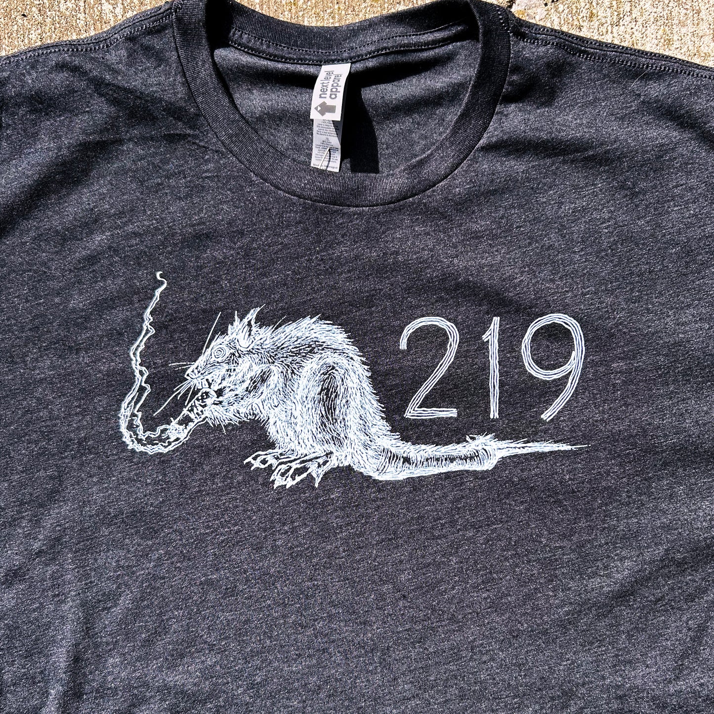 Region Rat 219 shirt charcoal grey short sleeve shirt with rat smoking cigarette in white ink shirt shown on concrete background