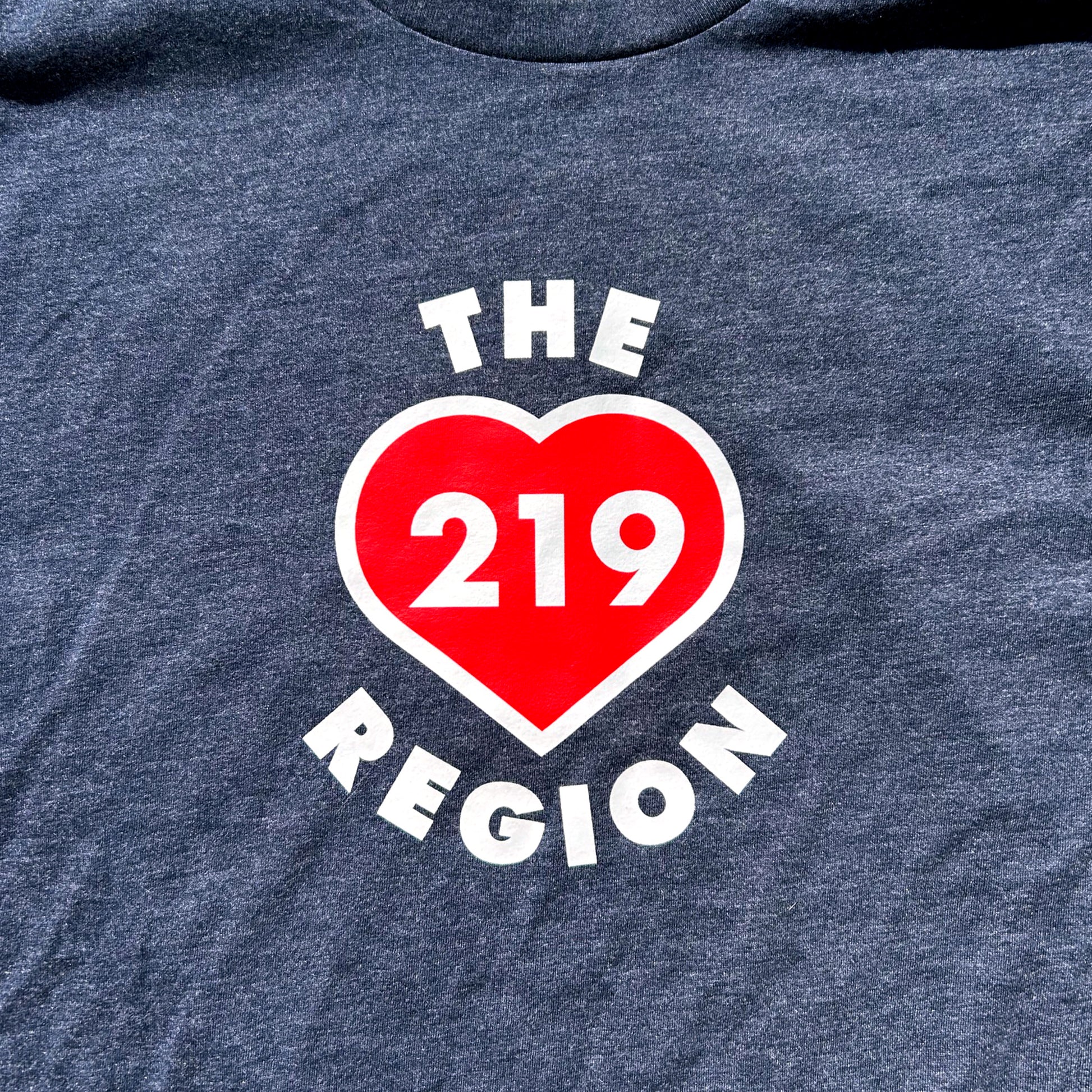 Navy blue t-shirt with a red heart and white text 'THE 219 REGION' on a dark background
