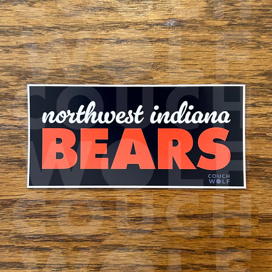 A rectangular bumper sticker with the words 'northwest indiana BEARS' on a navy blue background, placed on a brown wood surface. The sticker has a white border, with 'northwest indiana' in white script and 'BEARS' in large orange block letters.