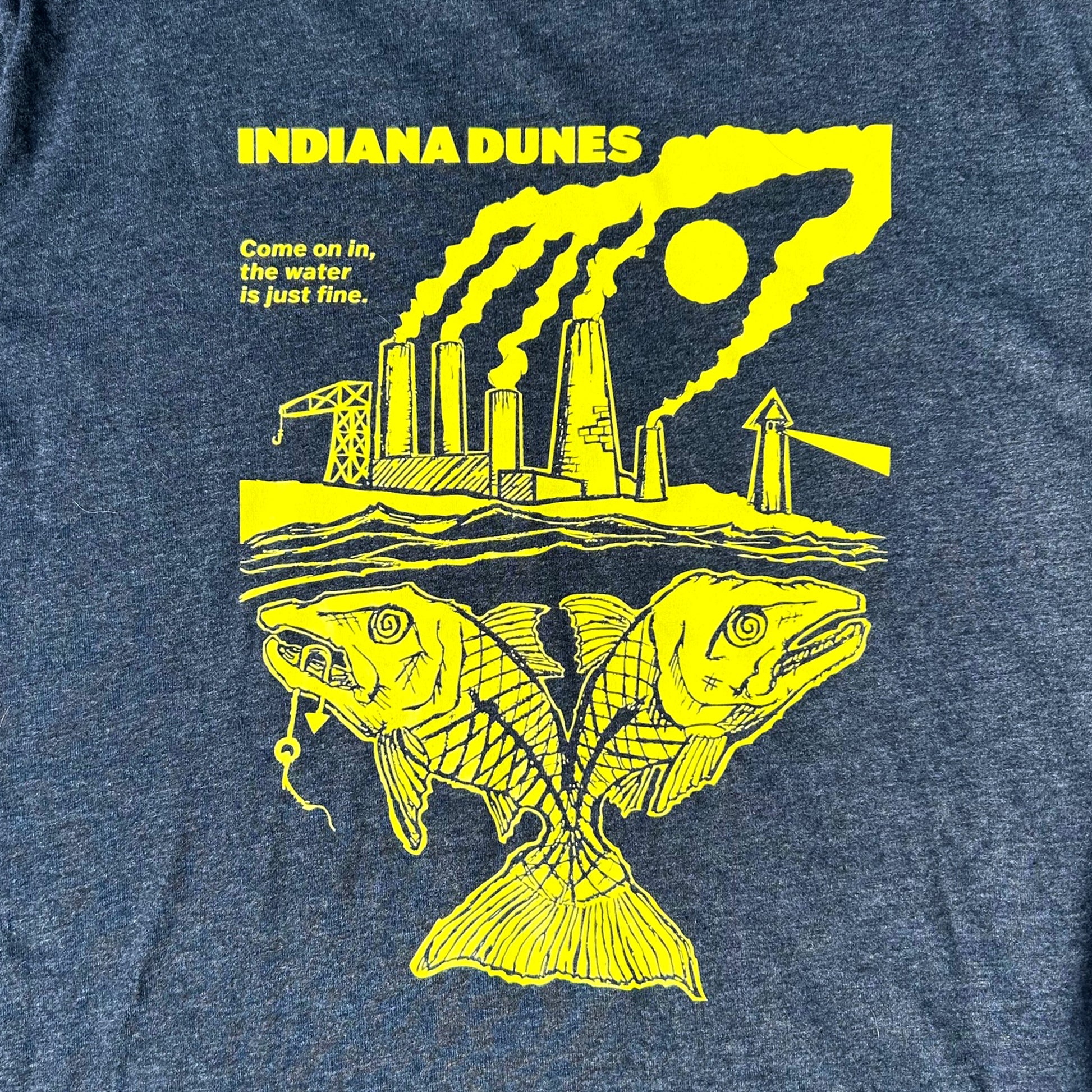 Blue t-shirt with yellow graphic of a factory and fish, featuring text 'INDIANA DUNES' and 'Come on in, the water is just fine'.