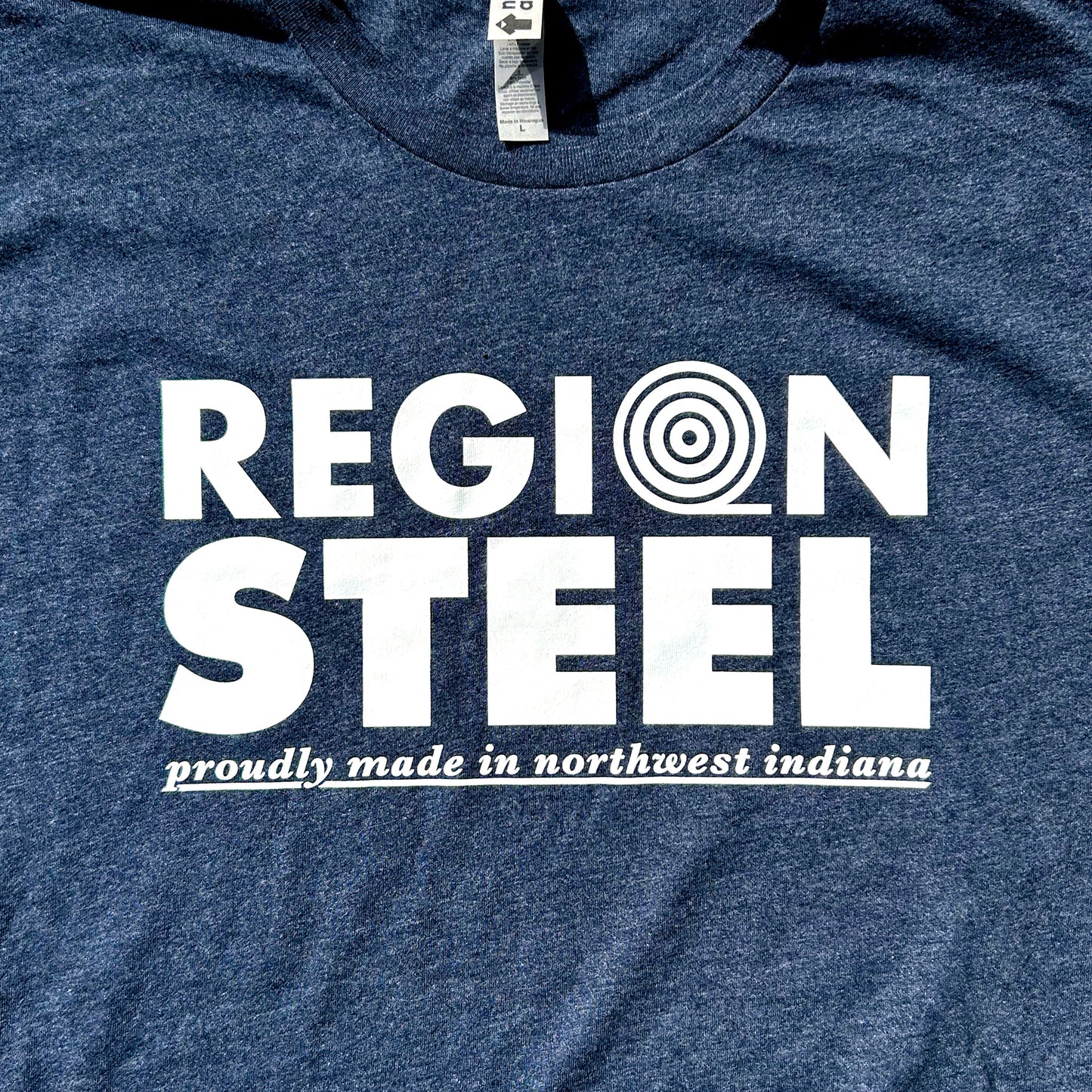 Region Steel Indiana T-shirt navy blue shirt with white bold letters that say "Region Steel proudly made in northwest Indiana close up of shirt chest