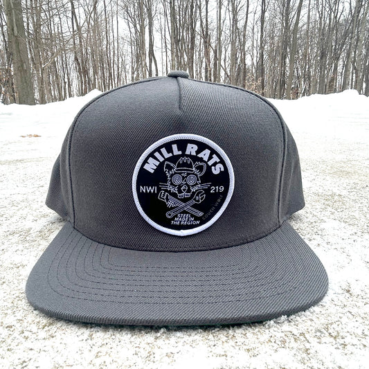 Gray cap with a Mill Rats rat  logo on a snowy ground with trees in the background