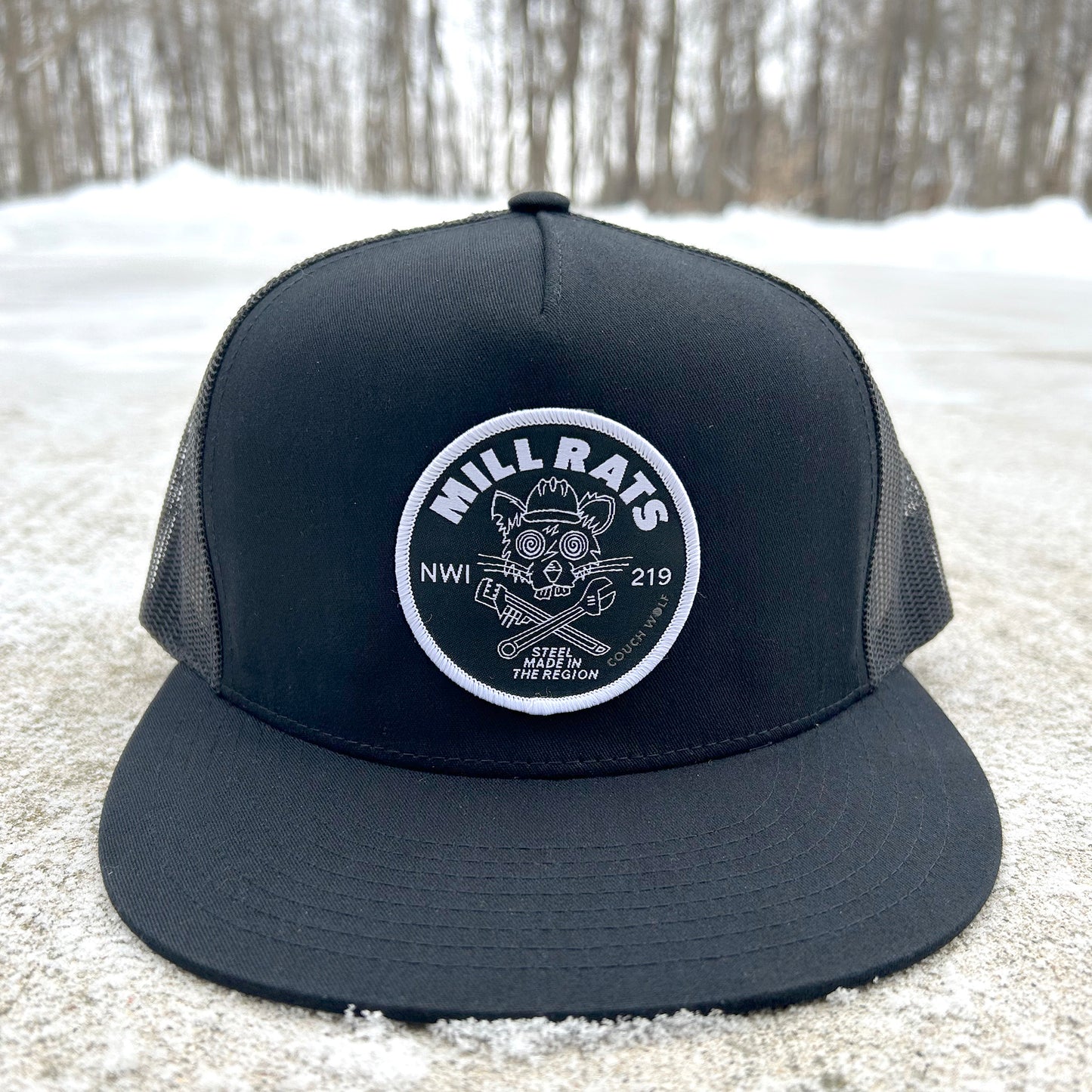 Black trucker hat with mill rats logo patch on a snowy ground