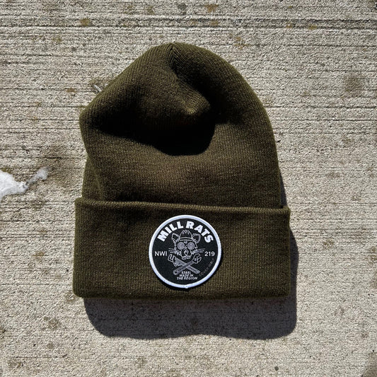 Green beanie with a black and white mill rats patch on a concrete surface