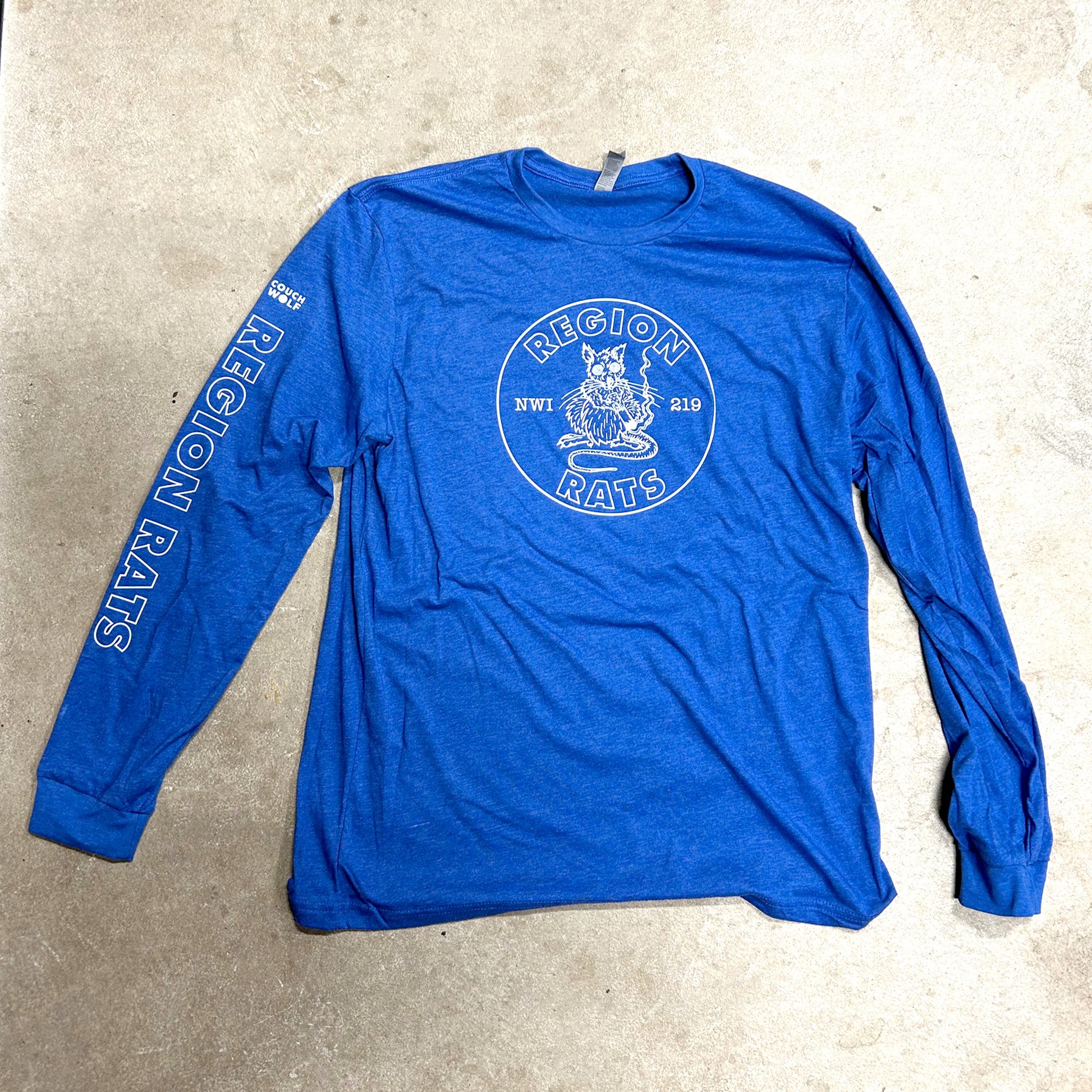 Blue long-sleeve shirt with 'Region Rats' logo on a beige surface