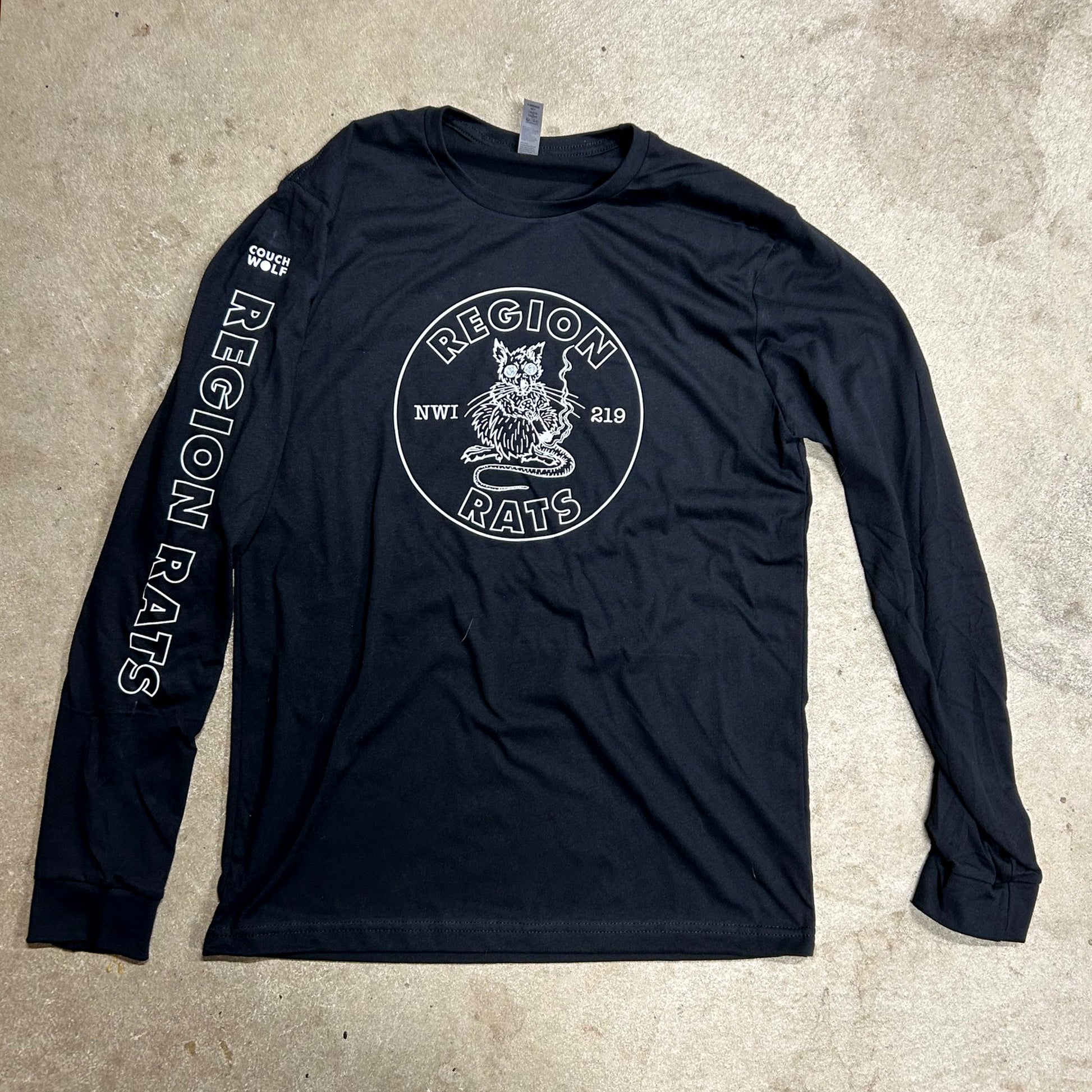 Black long-sleeve shirt with 'Region Rats' logo on a beige surface