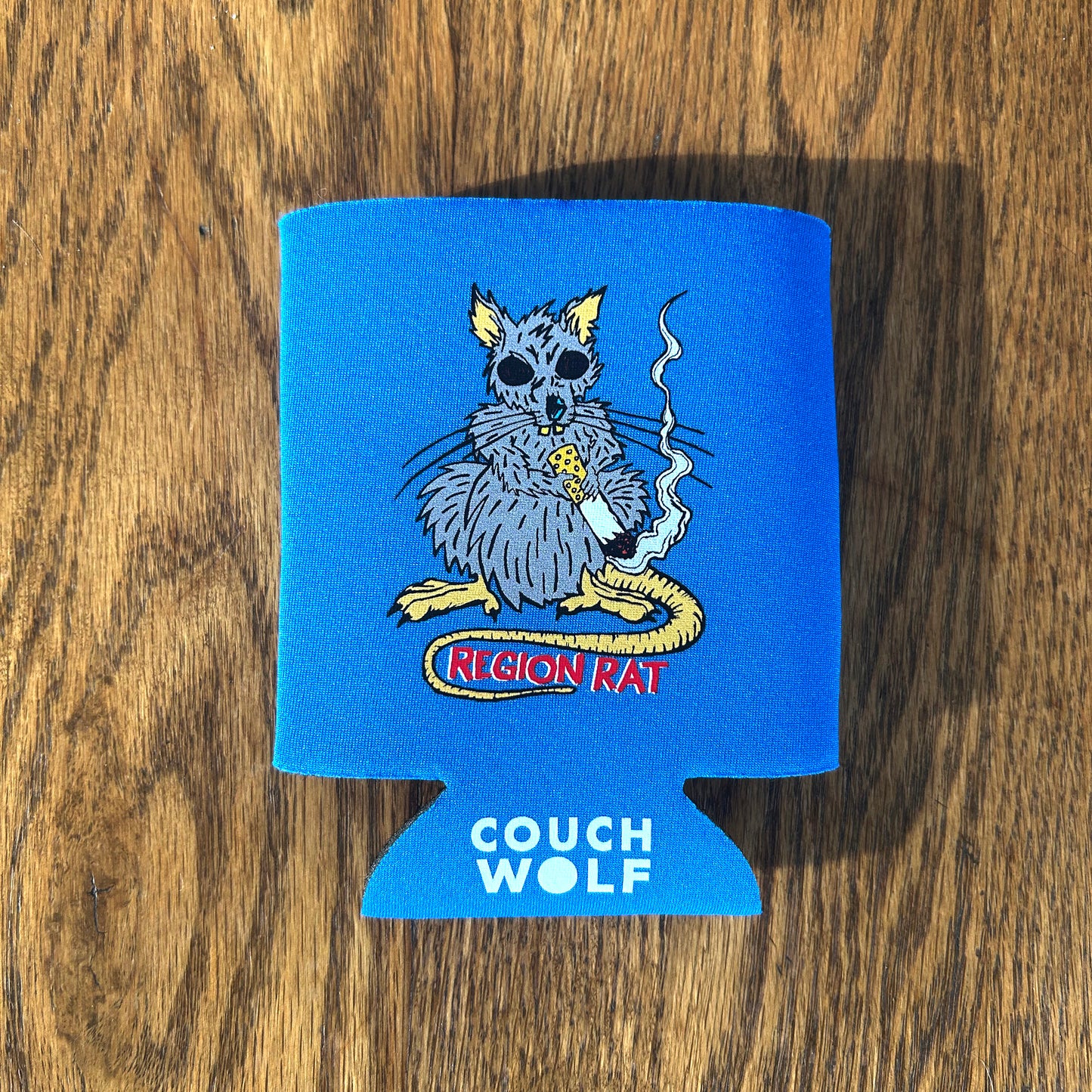 Region Rat can cooler, blue can cooler on wood background with gray rat graphic says 'Region Rat"