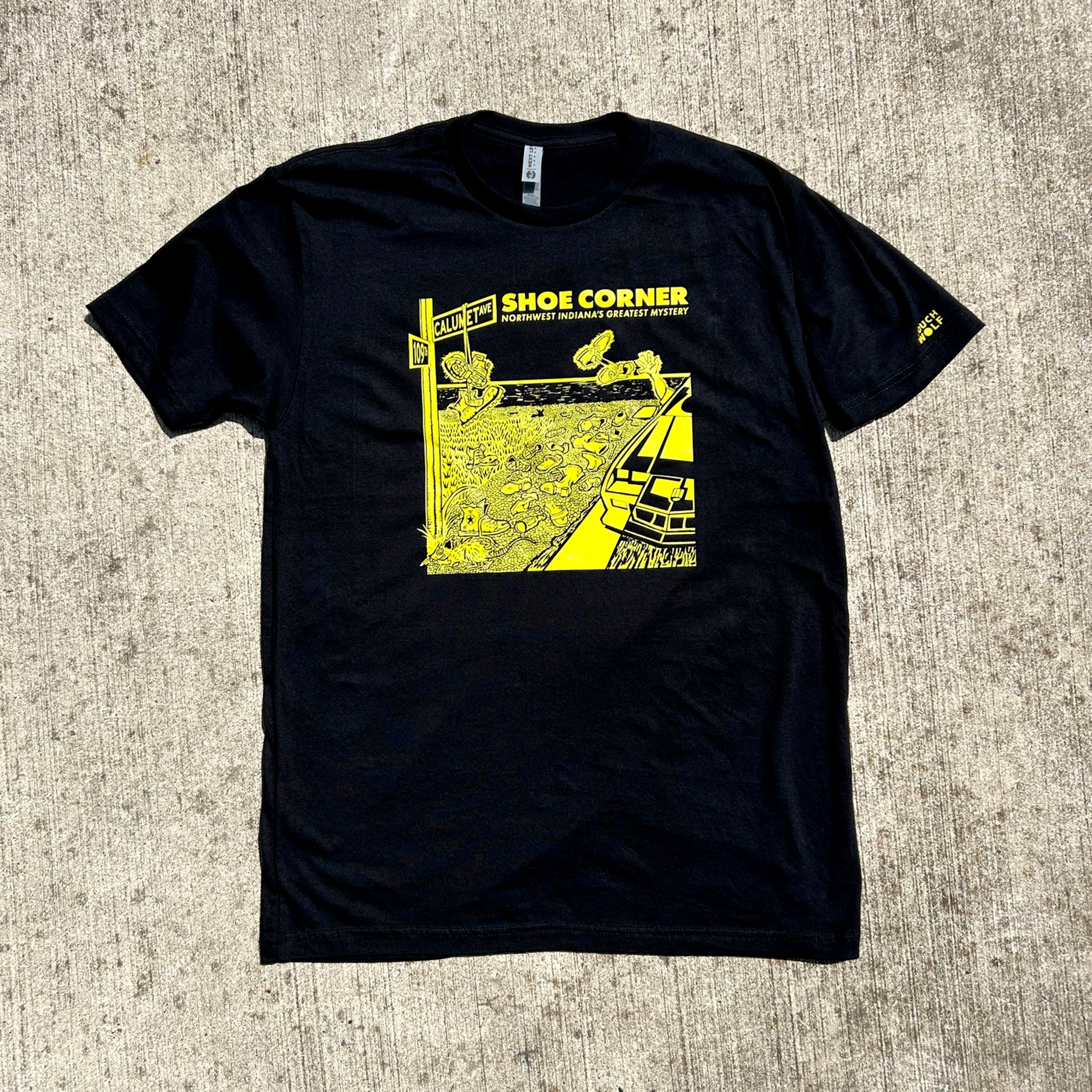 Black t-shirt with yellow graphic design on a textured surface