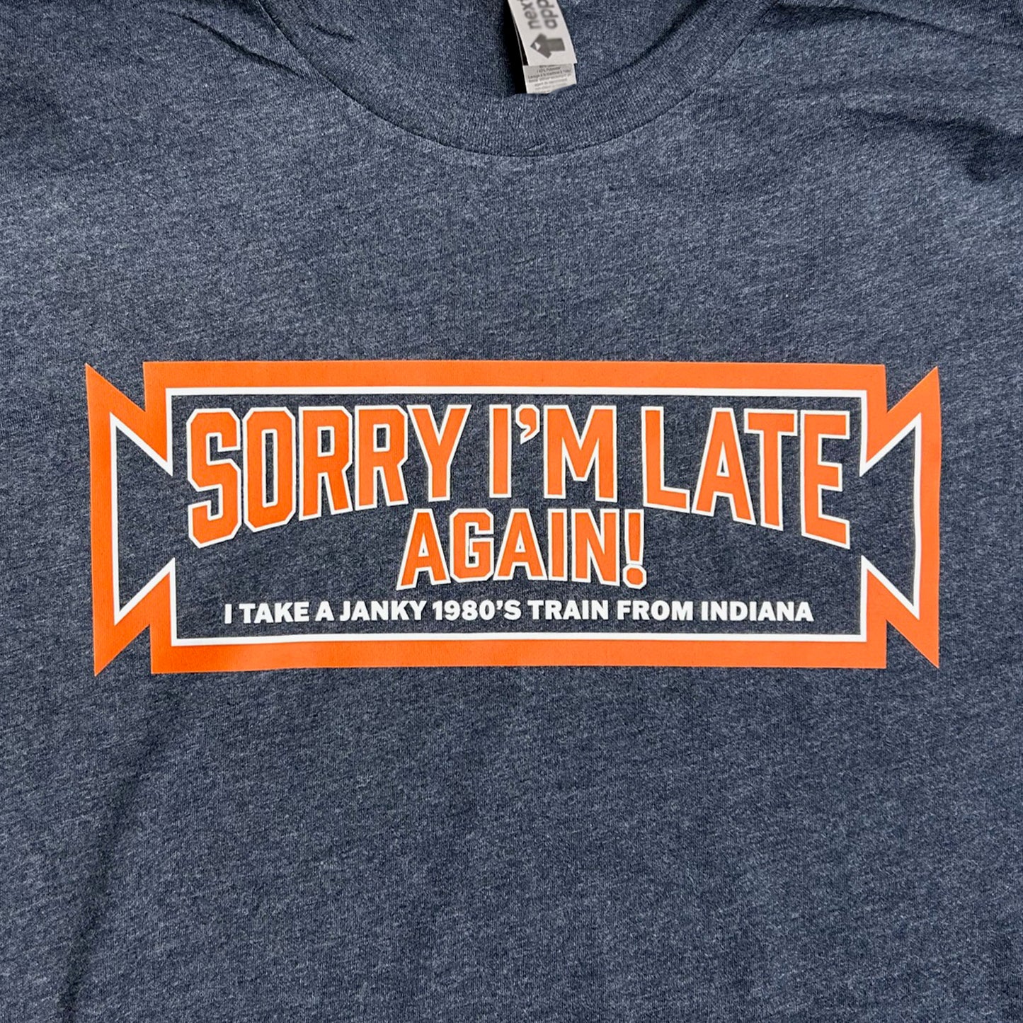 Blue South Shore  t-shirt with 'Sorry I'm Late Again! I take a janky 1980's train from Indiana" text design on a blur background